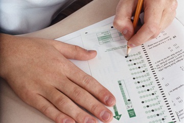 Two hands filling in scantron bubbles