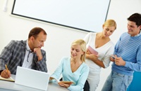 People talking and looking at a computer