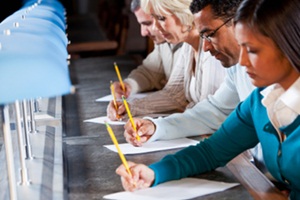 People in a row filling in test bubbles.