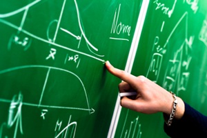 Hand pointing to graphs on chalkboard